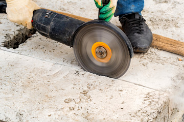 Close up worker cuts concrete with circular saw