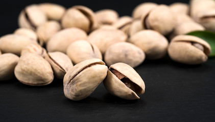 Pistachios nuts on dark background, top view, healthy snack