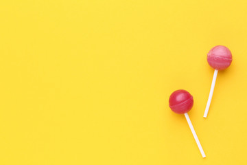 Sweet lollipops on yellow background