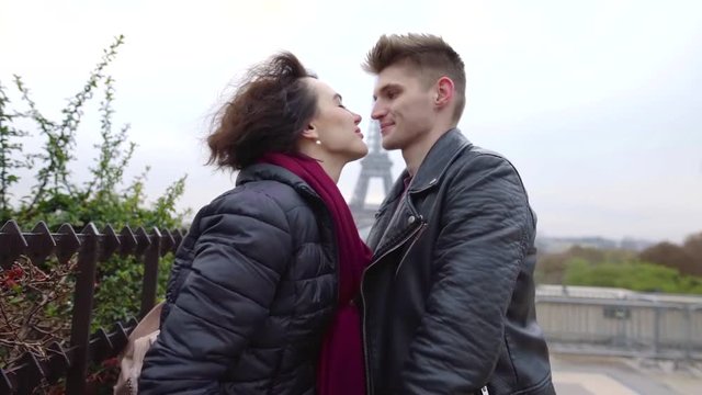Lovely young couple kisses outdoor in autumn meeting each other, boyfriend and girlfriend taking a walk in city.