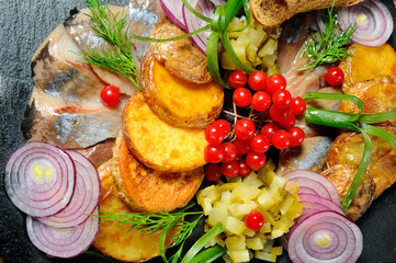 Restaurant dish - baked potatoes with onion rings and herring close-up