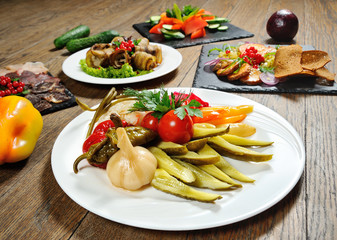 pickled onions, garlic, tomato, cucumber, pepper close-up on a plate. Homemade pickles in the restaurant menu