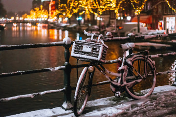 Obraz premium Bicycles Parked Along a Bridge Over the Canals of Amsterdam