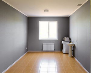 Not equipped empty kitchen room with bright window in new apartment building