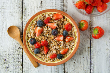 Healthy Homemade Oatmeal with Berries - fresh strwberries and blueberries, for Breakfast. Rustic white wooden table.