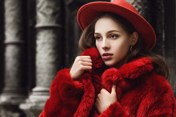 Outdoor close up fashion portrait of young beautiful confident woman wearing trendy orange faux fur...