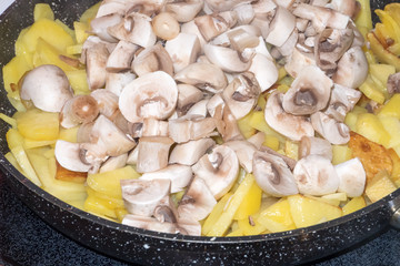 fried potatoes with mushrooms in a pan. Horizontal photo format