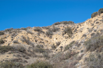 Rugged mountain side in autumn sunlight with blue sky for text