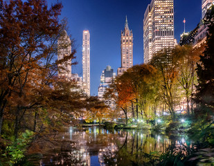 Fototapeta premium Autumn Night. 5th Ave Skyline View from The Pond of Central Park.
