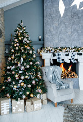 New Year's and Christmas interior in the hall with with fireplace and gray chair