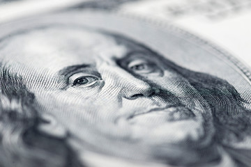 Benjamin Franklin's eyes from a hundred-dollar bill. The eyes of Benjamin Franklin on the hundred...