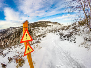 Ski warning sign pole on Wielki Rogacz Mount. Beskids Mountains in winter, Poland.