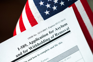 Fototapeta na wymiar Application for asylum to USA concept with application form and USA flag on mexican serape