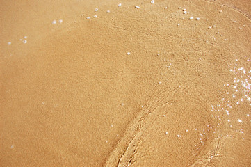 Fototapeta na wymiar Texture water fills the golden sand