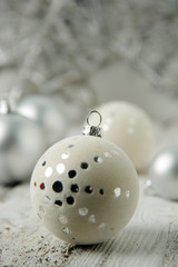 Christmas white background with silver decorative balls or baubles on rustic wooden background.