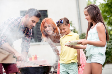 Young family make barbecue at their home