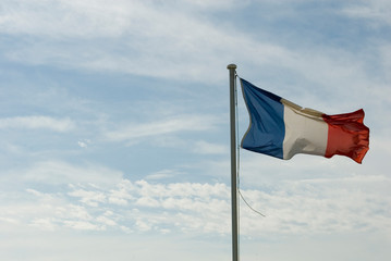 Naklejka na ściany i meble flag of france, blue, red and white, flying in the wind, worn and broken, sky with clouds, sun, patriotism, state, europe, government, freedom, equality, politics.