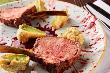Roasted lamb ribs with berry sauce and broccoli