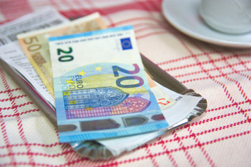 Payment of a cash account with a cup of coffee at a restaurant table