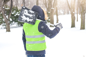 Back view of man with shovel winter scene.