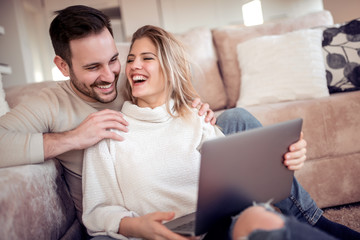 Obraz na płótnie Canvas Happy couple using laptop at home