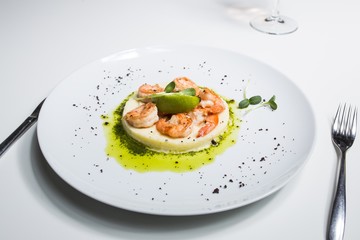 Shrimp with lime on a white plate close-up