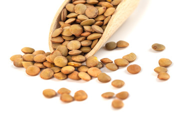 dry lentils on wooden spoon isolated on a white background