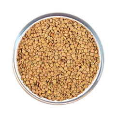 Dry lentil in glass bowl isolated on white background