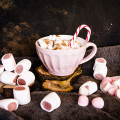 Good New Year spirit. Coffee with marshmallows and cinnamon. Candy canes. Pink mug. Cooking...