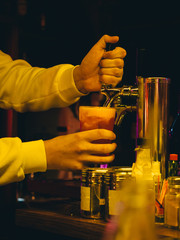 Cocktail in glass in hand. Bar restaurant background