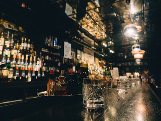 Bar stand with bottles of alcohol in dark