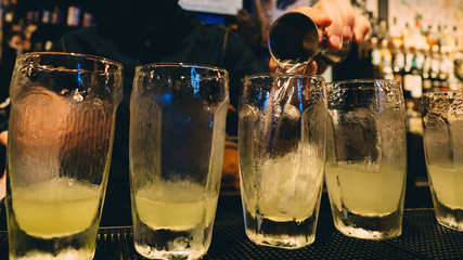 Gin tonic cocktails in glasses in bar stand