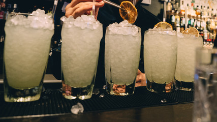 Gin tonic cocktails in glasses in bar stand