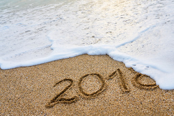                            The year 2018 passed the concept. The wave of foam washes away the inscription 2018 written on the sand.   