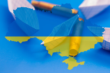 Large paper boats attacking a small boat on blue background with a map of Ukraine. Sleeves on the map of Ukraine. The military conflict between Russia and Ukraine in the Kerch Strait in the Black Sea.
