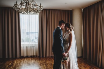 Obraz na płótnie Canvas Wedding photo shoot of the newlyweds in a dark hotel room.