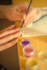 The process of creating a design on the nails.