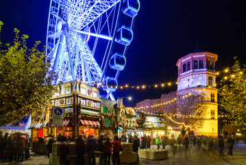 Night colorful atmosphere of Weihnachtsmarkt, Christmas market, in Düsseldorf, the ferris wheel...