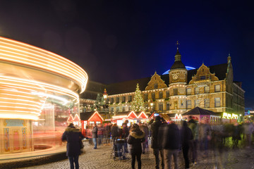 Obraz premium Night colorful atmosphere of Weihnachtsmarkt, Christmas market, in Düsseldorf, the carousel and christmas theme decorated booths set up at the old town.