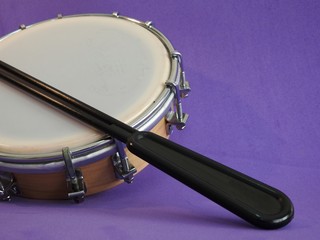 Tamborim and drumstick: a small, round Brazilian frame drum. It is widely used to accompany samba....