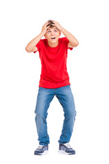 Cute child covered his head with his hands. Full length portrait of caucasian teen boy wearing red t-shirt. Funny teenager is afraid something fall on him, isolated on white background