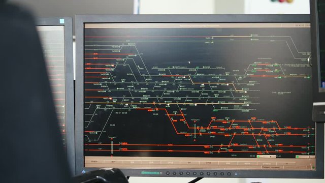 Man watching movement of trains on computer monitor