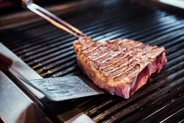 Close-up image of a cooking delicious meat steak on a grill