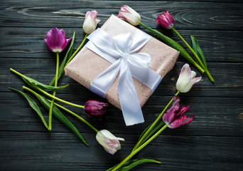 Obraz na płótnie Canvas colorful beautiful tulips, gift box on the gray wooden table. Valentines, spring background. floral mock up with copyspace. happy mothers day, romantic still life, fresh flowers
