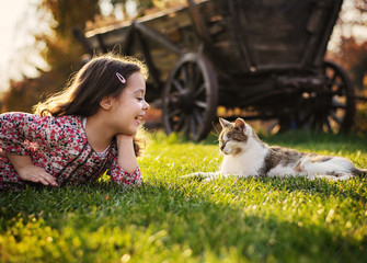Cute little girl smiling to a cat