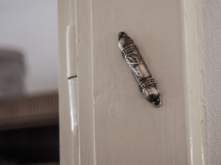 Mezuzah, a decorative case with piece of parchment called a klaf. Doorpost of a Jewish house.