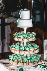 green style wedding candy bar on a white table. cupcakes decorated with a green ribbon bow