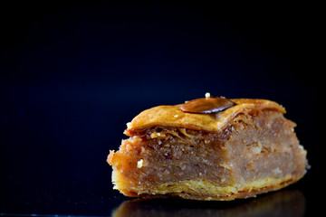 Middle Eastern dessert called mabroume or bahlava isolated on black background.