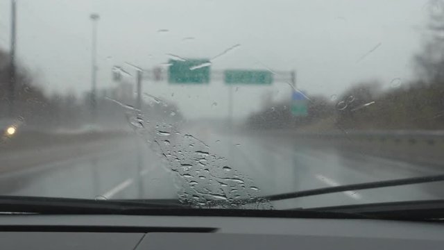 Slow motion drive on rainy highway. Detail of windshield. Don Valley Parkway, Toronto, Ontario, Canada.