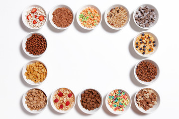 frame of breakfast cereal. bowls of different cereal and cornflakes. isolated on white background. ...